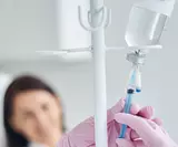 Медсестра готовит капельницу для пациентки